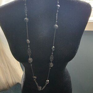 Long black beaded necklace with filigree detailing